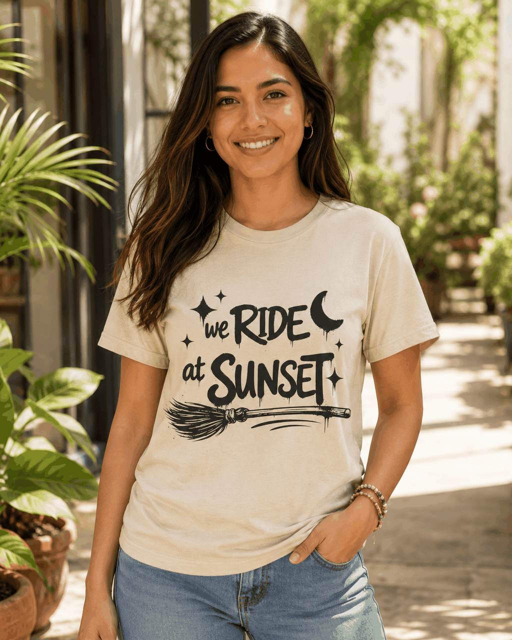 We Ride at Sunset T-shirt, Natural tee modeled outdoors with moon, stars and broom graphic
